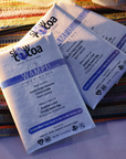 Two packages of slowcocoa 70% Wampu chocolate on a striped fabric background