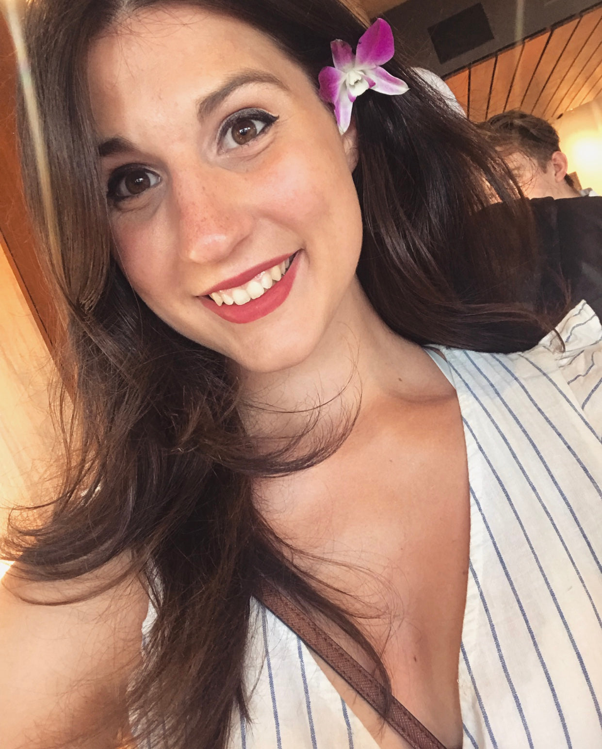 Woman with a flower in her hair smiling outdoors