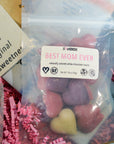 Packaged candy with a 'Best Mom Ever' label and visible brand name on a colorful background.